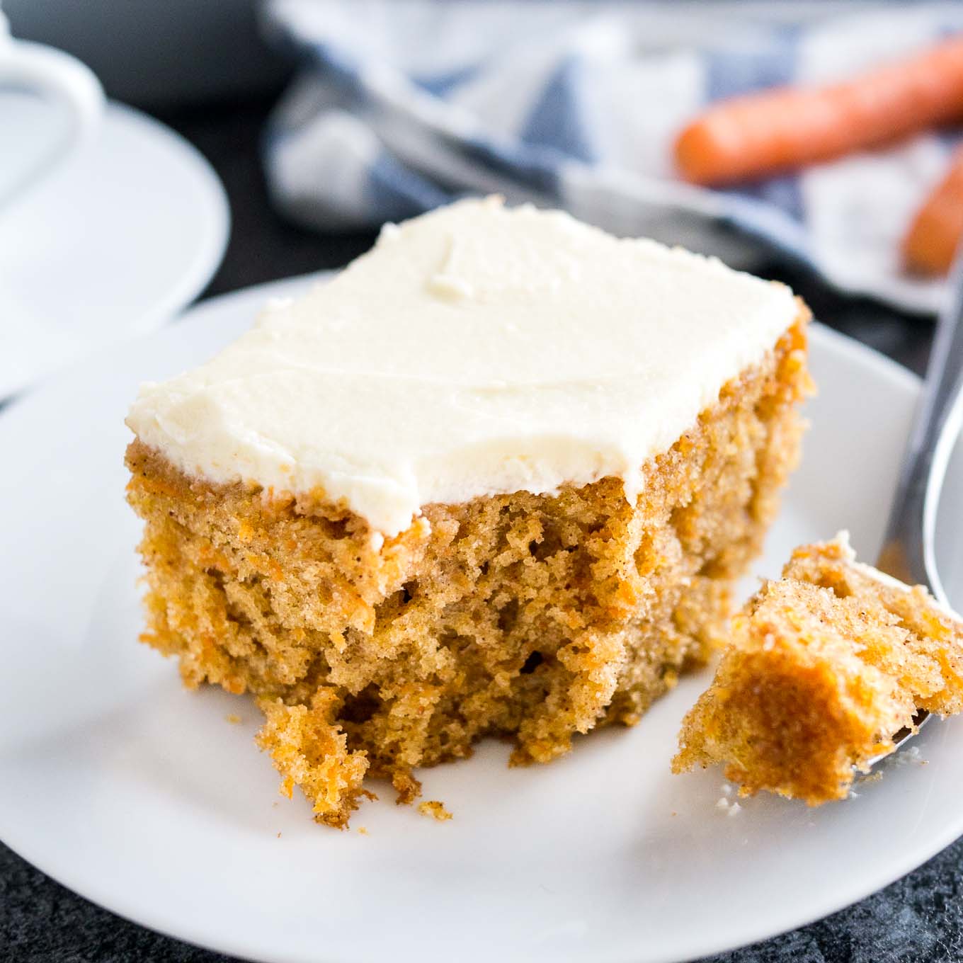 This easy Carrot Cake is deliciously moist and topped with a smooth cream cheese frosting! A nut-free sheet cake that is ready in 30 minutes and super simple to throw together.