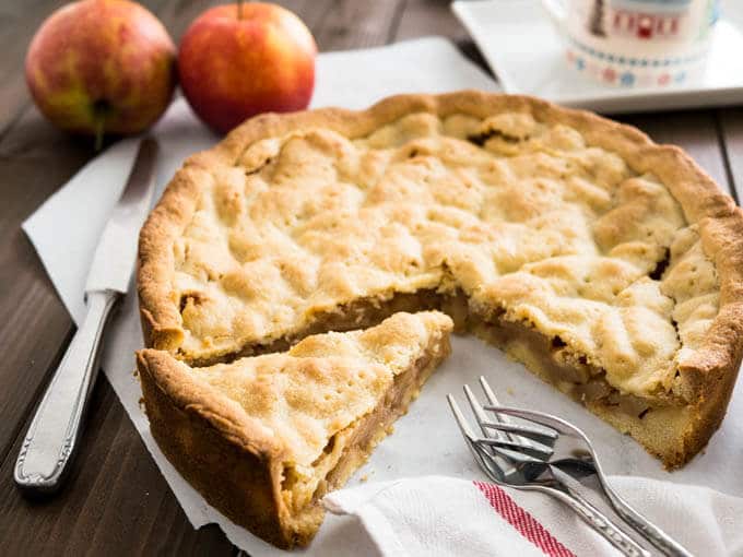 Covered German Apple Cake is one of the best apple cakes! Filled with cinnamon-seasoned apple chunks and topped with a vanilla shortbread crust. You can get this cake in every German bakery!