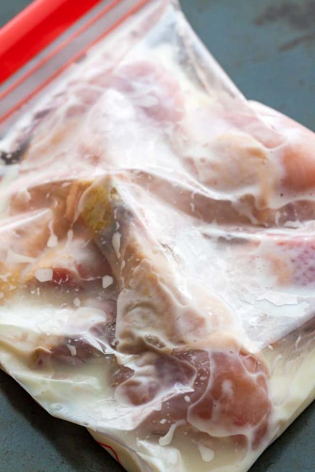 raw chicken drumstick in a zipper bag filled with buttermilk