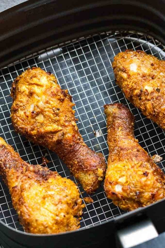 breaded chicken drumsticks lying in an air fryer basket