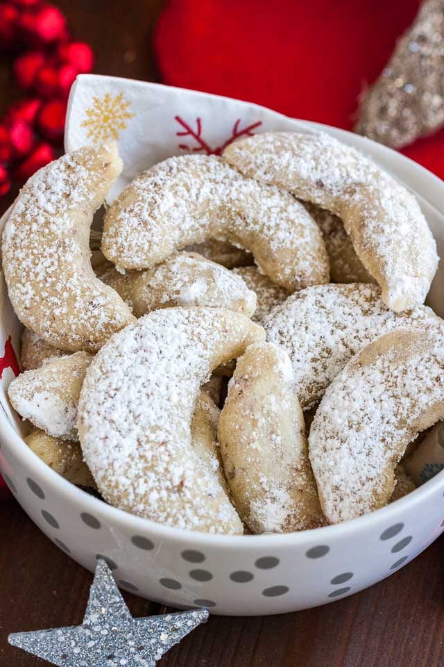 Close-up of a white bowl with a napkin, of Vanillekipferl cookies.