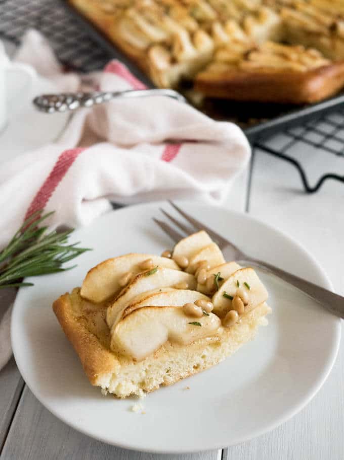 This Apple Cake Recipe is perfect for fall! Yeast dough is brushed with cinnamon butter, topped with fresh apple slices and glazed with honey and pine nuts.