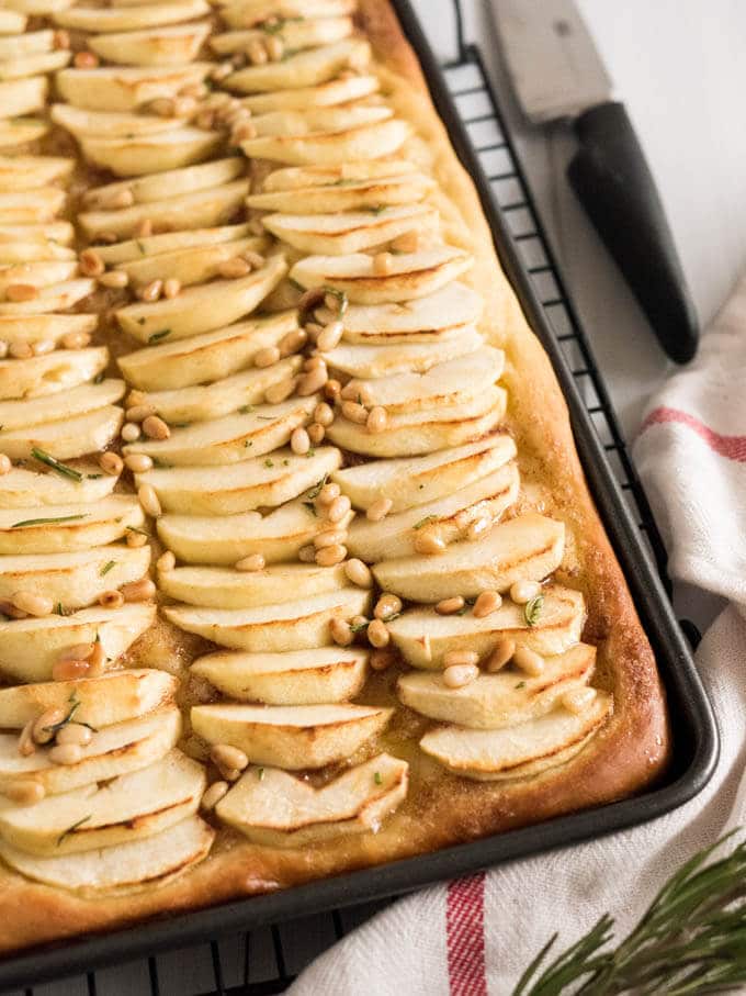 This Apple Cake Recipe is perfect for fall! Yeast dough is brushed with cinnamon butter, topped with fresh apple slices and glazed with honey and pine nuts.