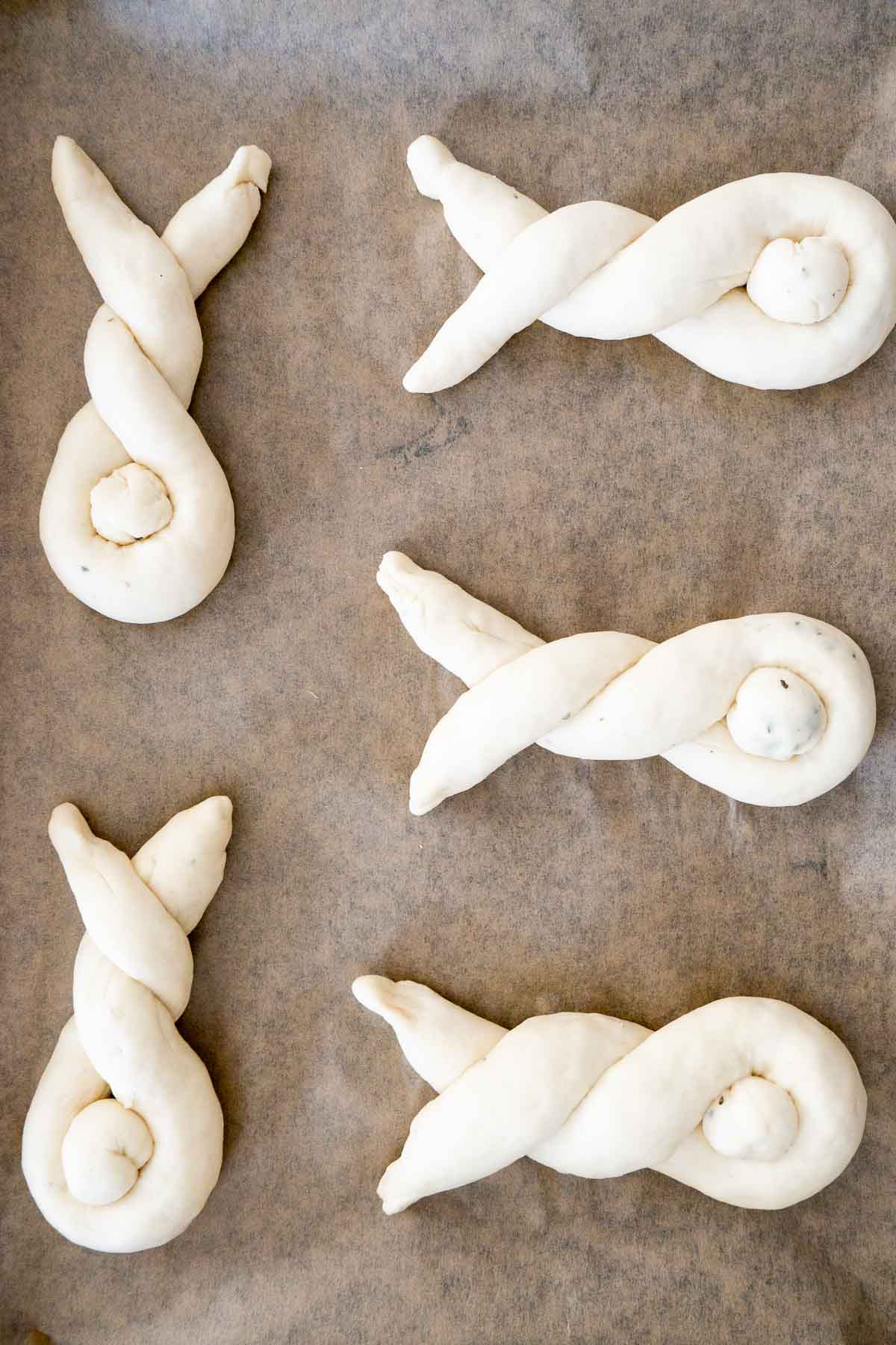 Shaped bunny rolls on parchment paper.