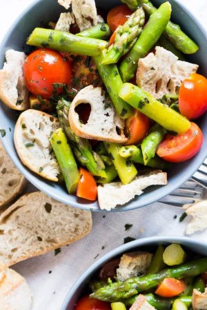 Asparagus Panzanella is made with sweet cherry tomatoes, crispy homemade ciabatta bread chips, and green asparagus! A perfect salad recipe for spring.