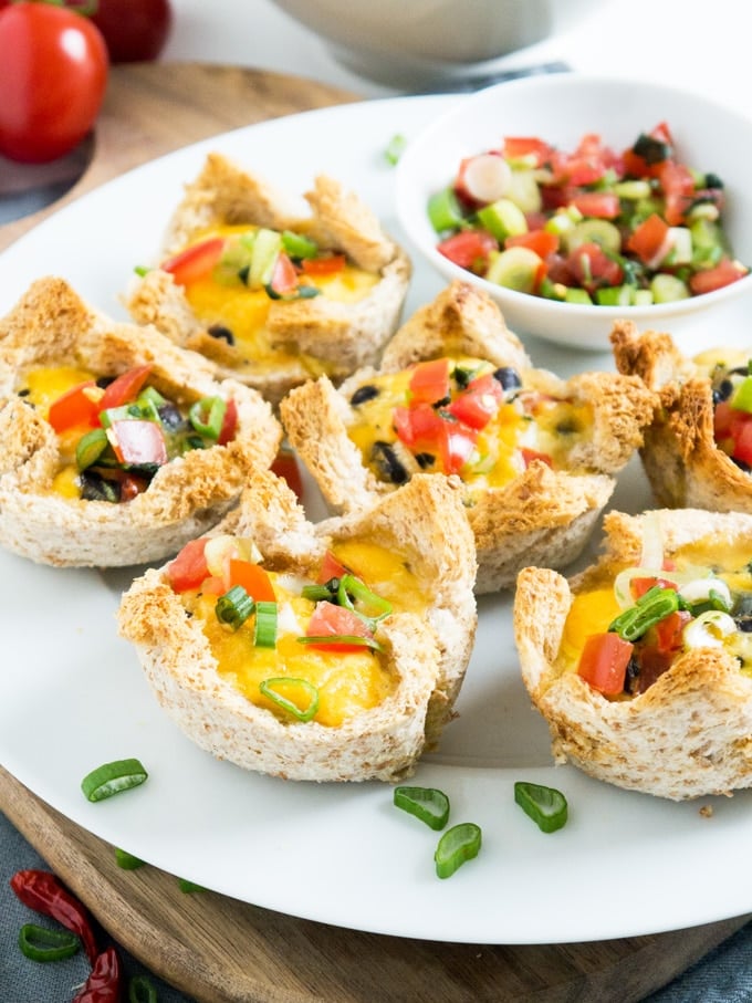These cheesy Mexican Toast Cups are made in a muffin tin with sandwich bread! Filled with black beans, homemade salsa, cheese and eggs. Perfect for brunch or as a party snack!