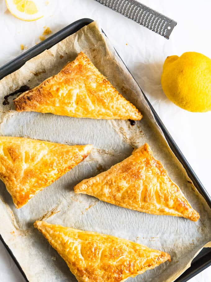 Lemon Puff Pastry Pockets are a perfect summer treat! Crispy caramelized puff pastry with a lemon & ricotta cheesecake filling.