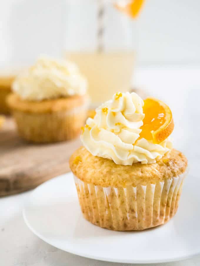 These Coconut Orange Creamsicle Cupcakes are a tropical taste explosion! An orange-infused coconut vanilla cupcake topped w/ orange buttercream or glaze.