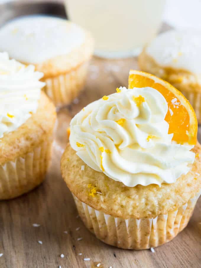 These Coconut Orange Creamsicle Cupcakes are a tropical taste explosion! An orange-infused coconut vanilla cupcake topped w/ orange buttercream or glaze.