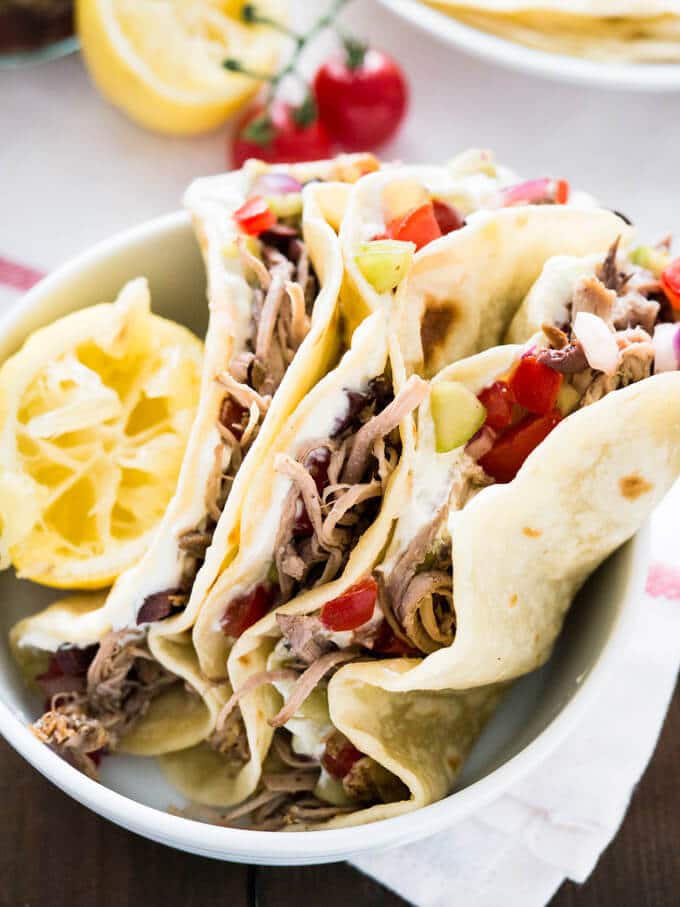 Delicious Greek Tacos with homemade Tzatziki, slow cooker pulled pork Gyros and Greek salsa. Served on homemade flour tortillas! A great twist on normal tacos!