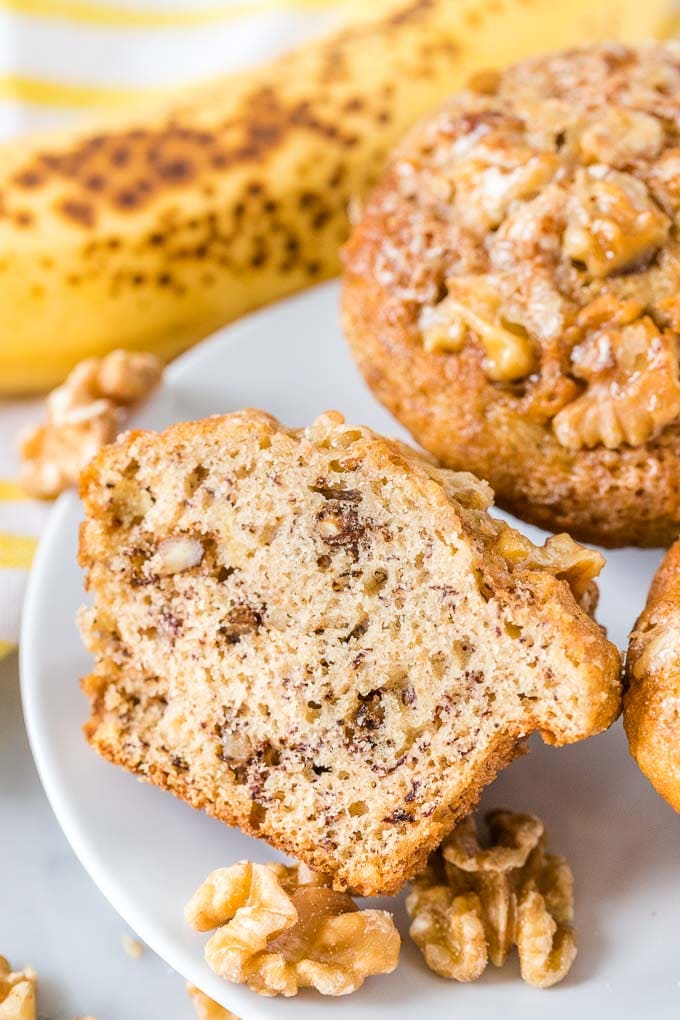 Banana Nut Bread Muffins on a plate with a banana in the background.