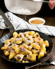 This Kaiserschmarrn recipe is perfect for your Oktoberfest party but it also makes a great dessert for other special occasions! A fluffy pancake made with rum-soaked raisins is torn into bite-sized pieces, caramelized, and served hot sprinkled with Confectioners' sugar.