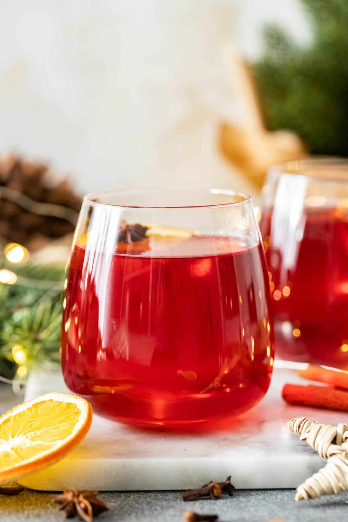 A glass filled with non-alcoholic Christmas Punch on a marble board.