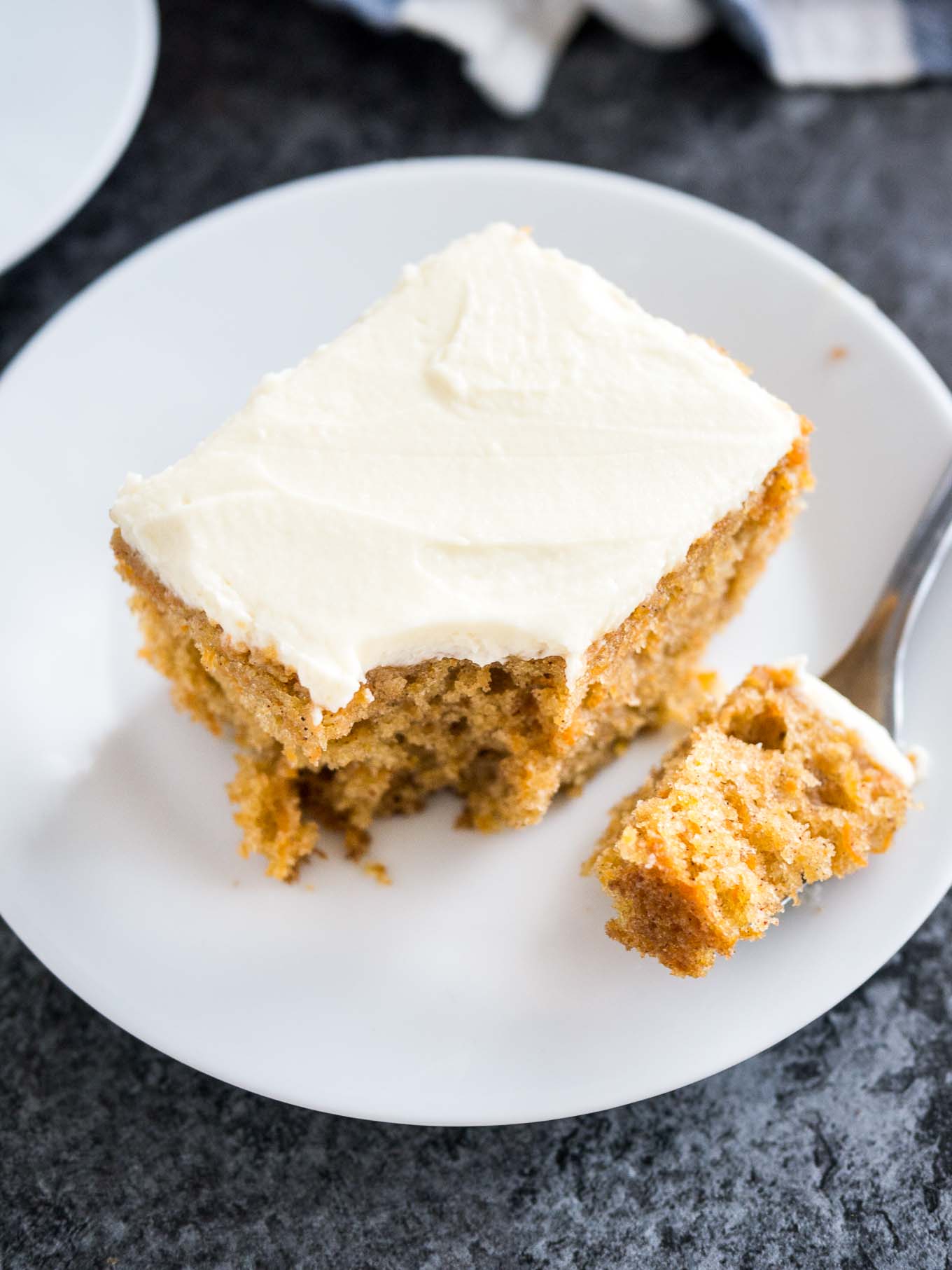 This easy Carrot Cake is deliciously moist and topped with a smooth cream cheese frosting! A nut-free sheet cake that is ready in 30 minutes and super simple to throw together.