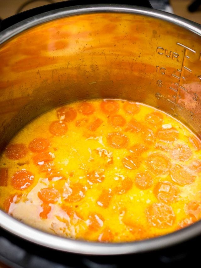 An instant pot with carrot soup with whole pieces of carrots in it.