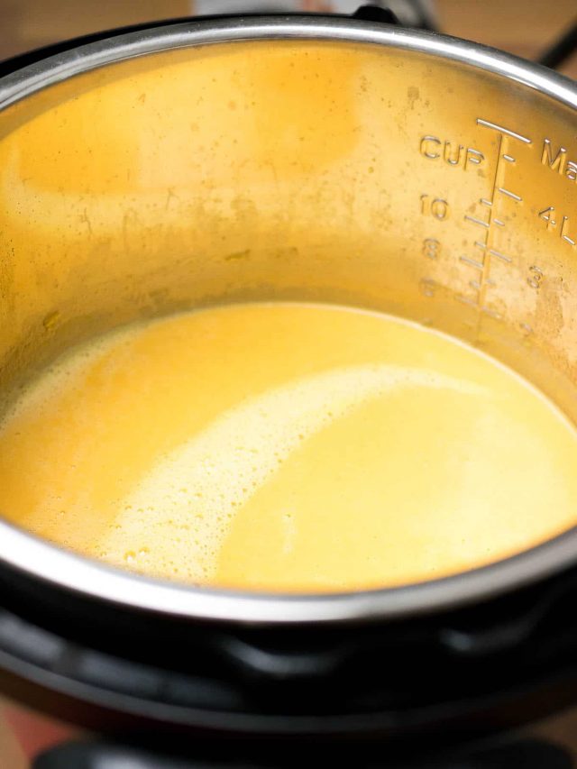An instant pot with carrot soup that has been blended.