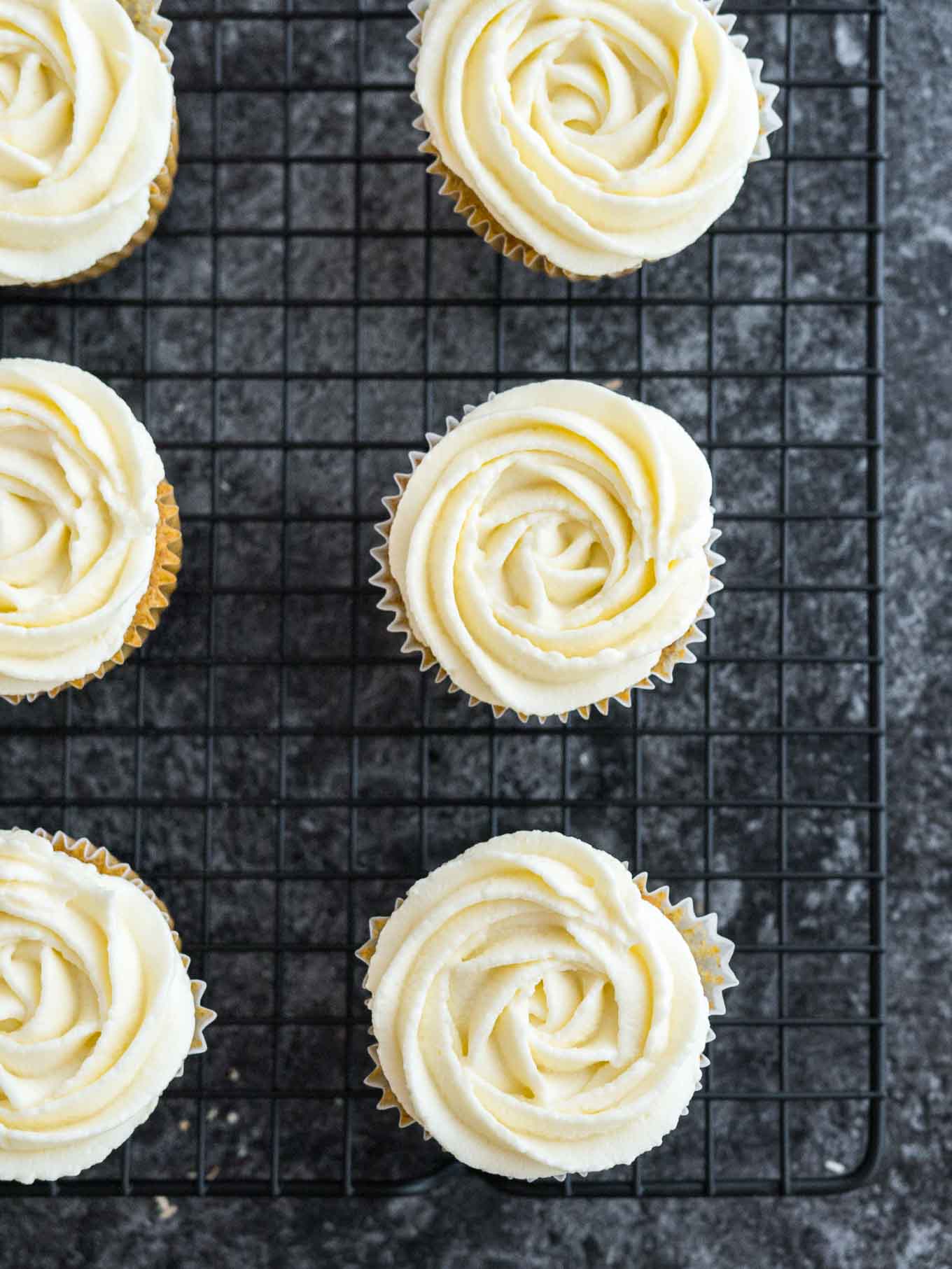 Frosted cupcakes on a cooling rack.
