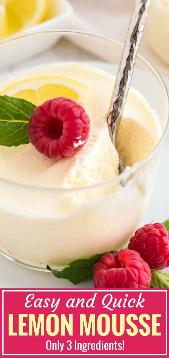 Close-up of a glass of lemon mousse garnished with mint, raspberry and a lemon slice with a spoon scooping out a bite of it.