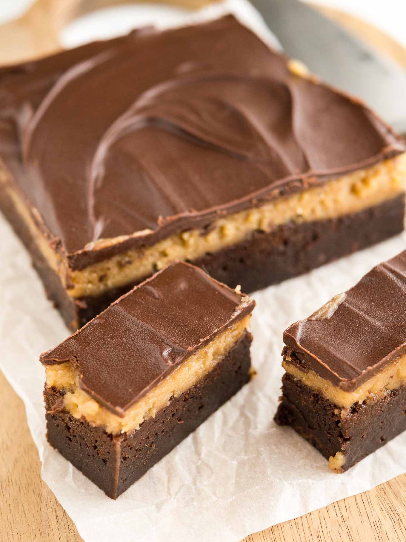 Peanut butter brownie bars on a wooden cutting board lined with parchment paper.