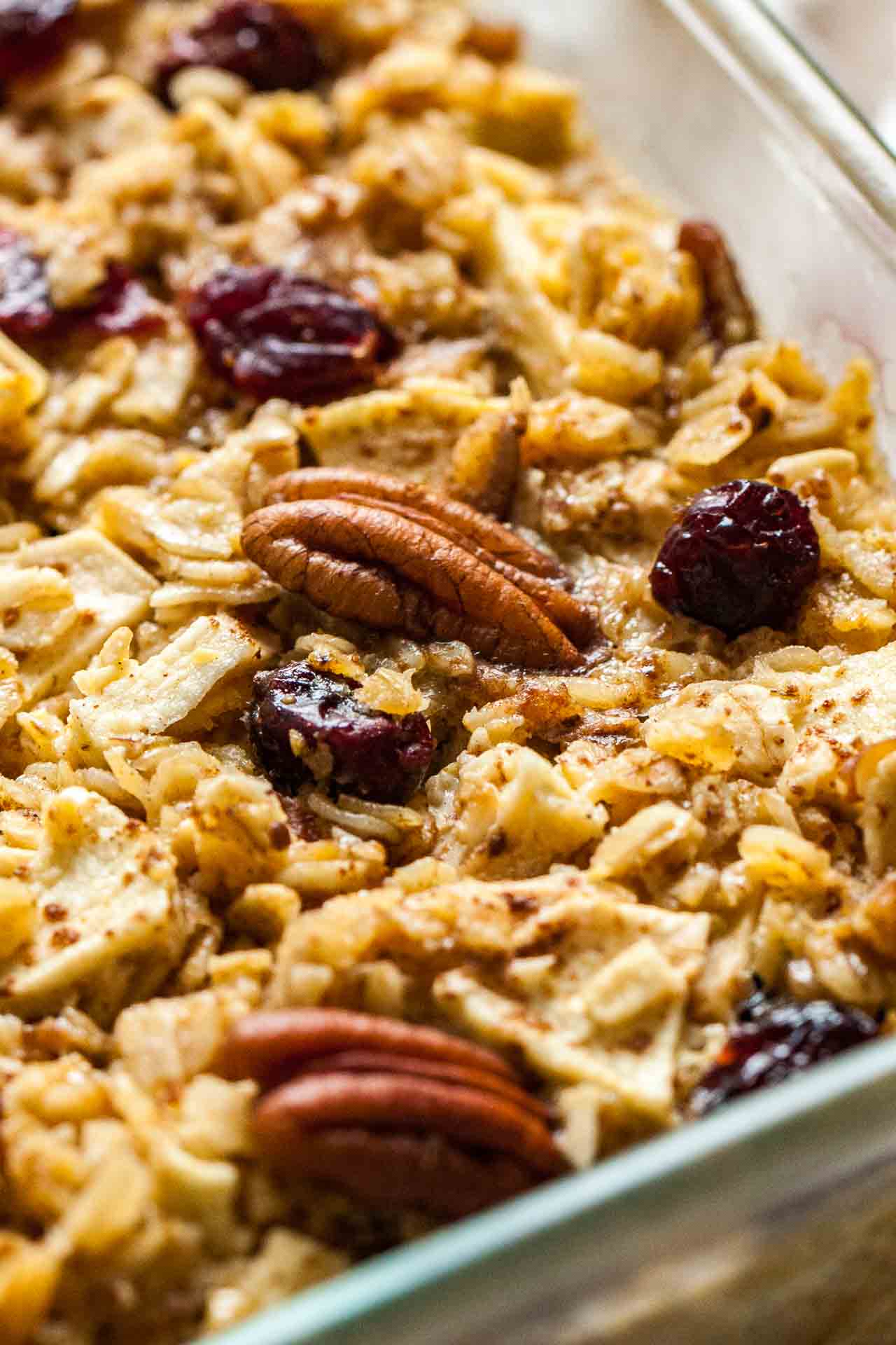 Close-up of a glass baking dish with baked oatmeal with apples, pecans and cranberries.