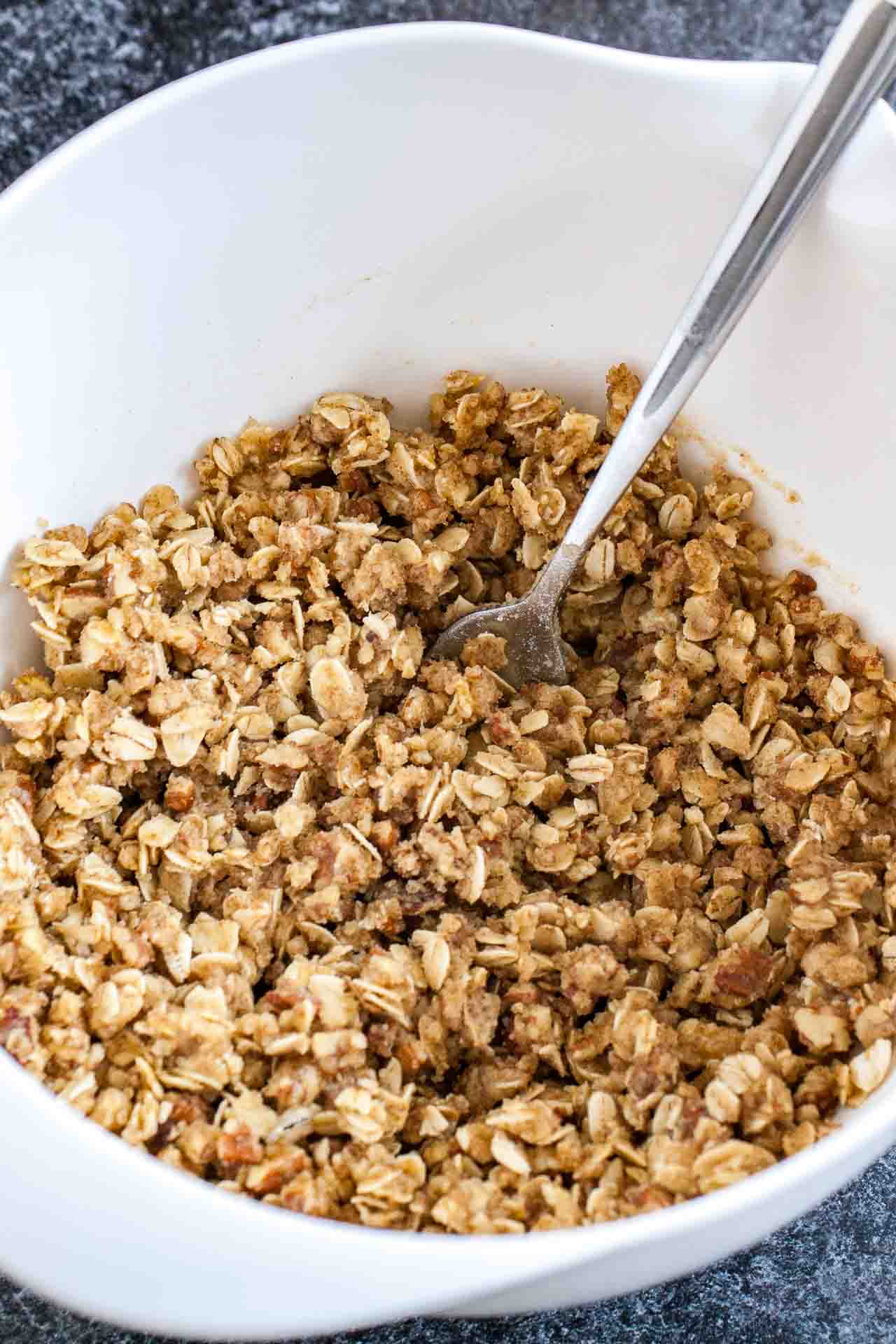 A white bowl with oatmeal and brown sugar with a fork.