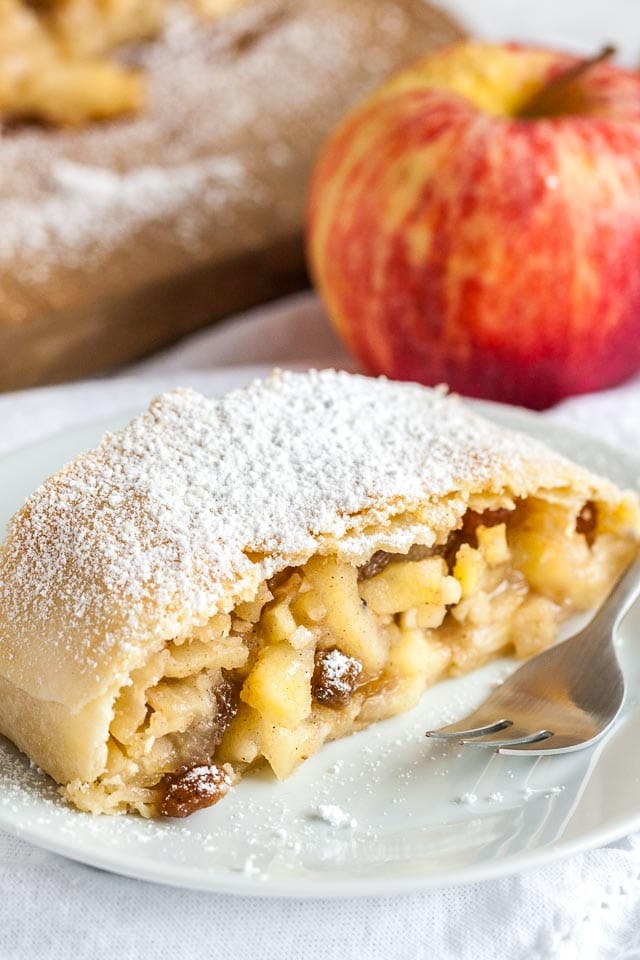 Apple Strudel is much easier to make from scratch than you think and tastes amazing dusted with powdered sugar! Everyone will love this traditional Apfelstrudel that has a flaky crust and is filled with juicy spiced apples.