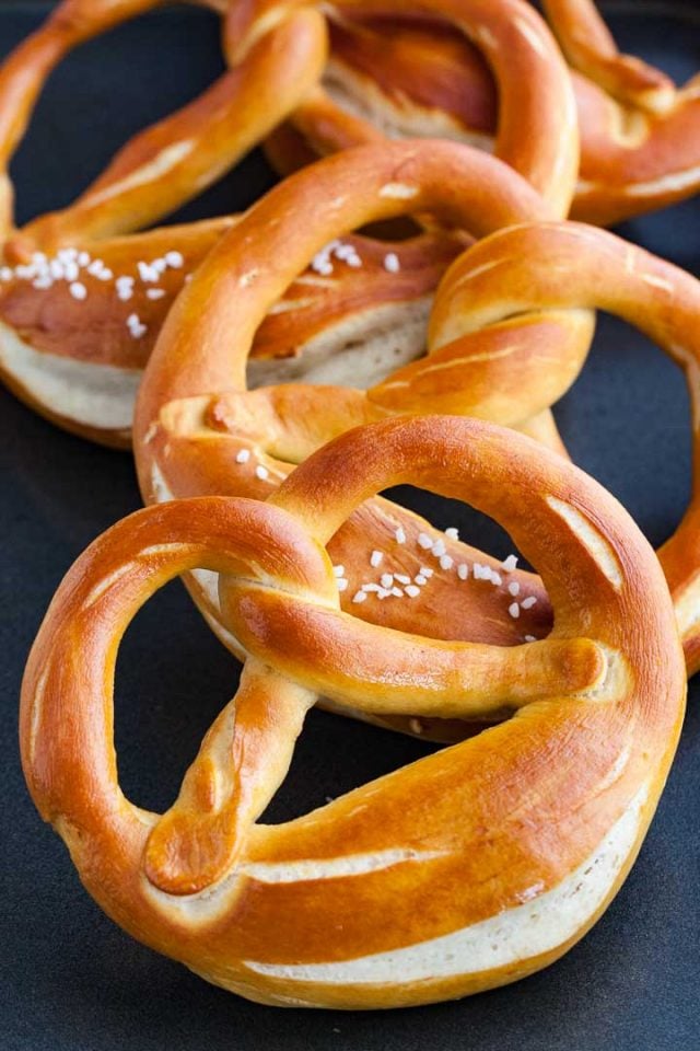 Three pretzels on a dark blue surface.