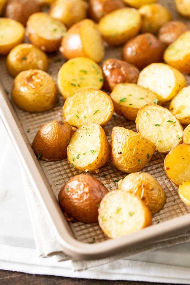 A baking sheet with roasted potatoes, garnished with parsley.