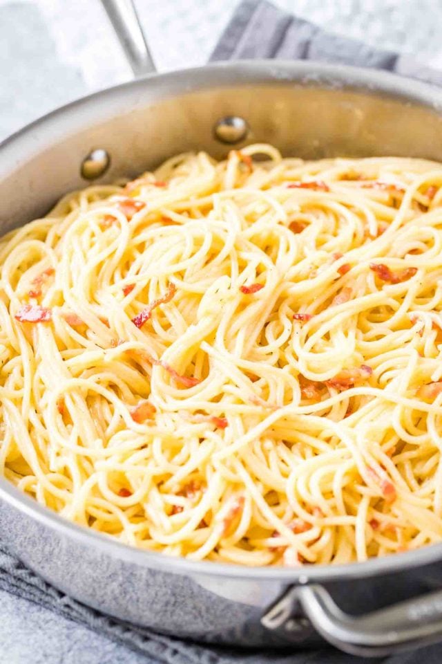 A stainless steel pan with spaghetti carbonara