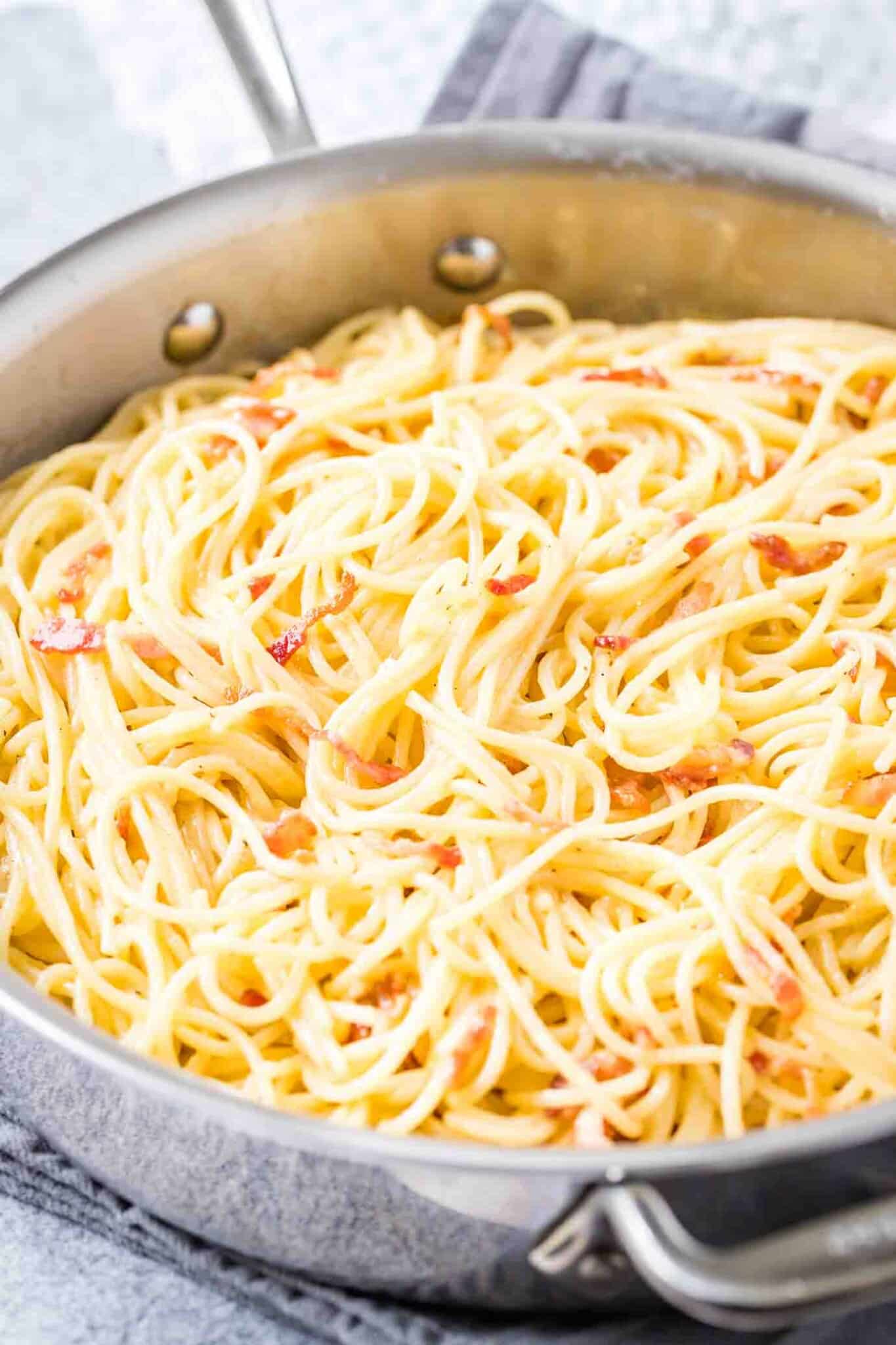 A stainless steel pan with spaghetti carbonara