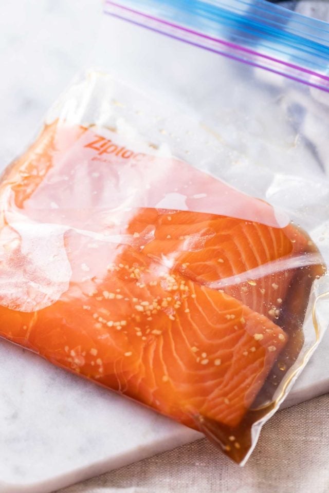 two pieces of salmon in a zipper bag with teriyaki sauce