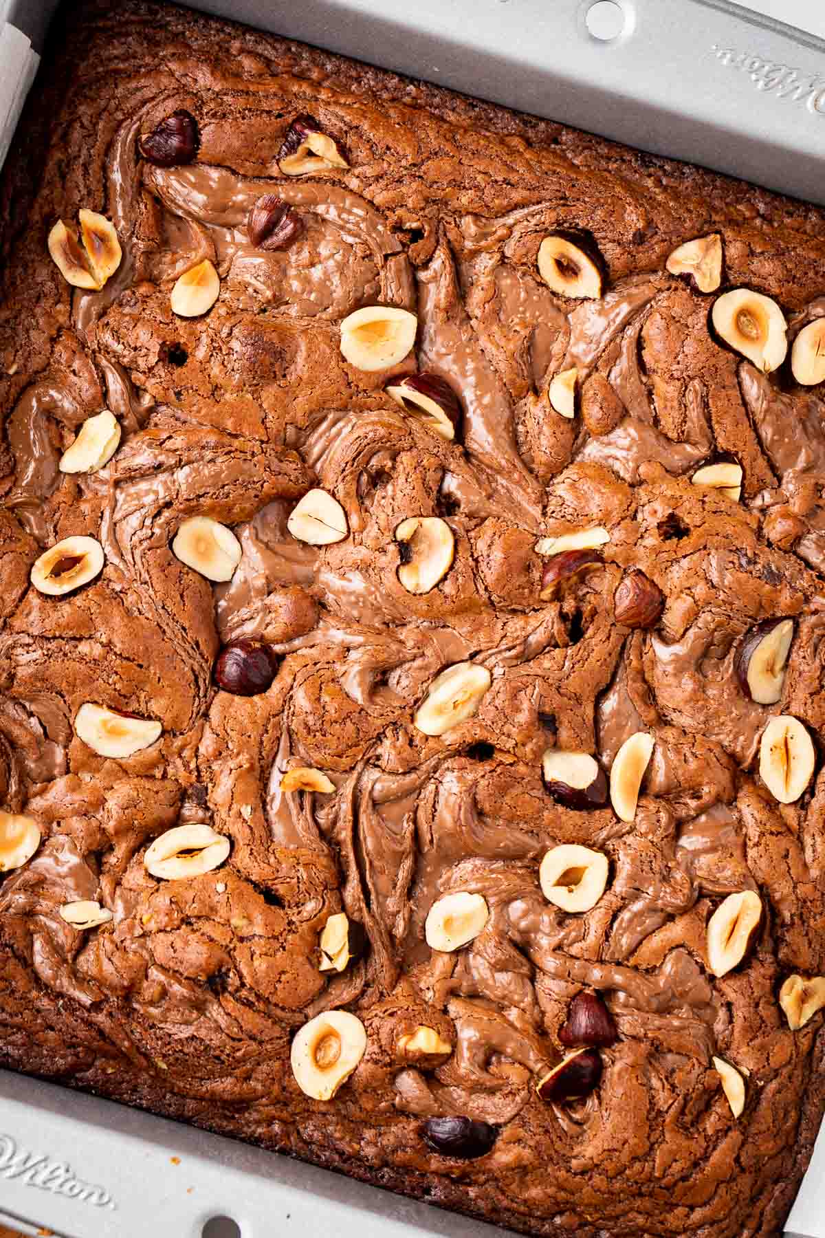 Brownies sprinkled with hazelnuts and swirls of Nutella.