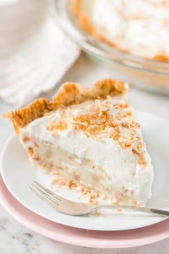 A slice of Coconut Cream Pie on a plate with a fork