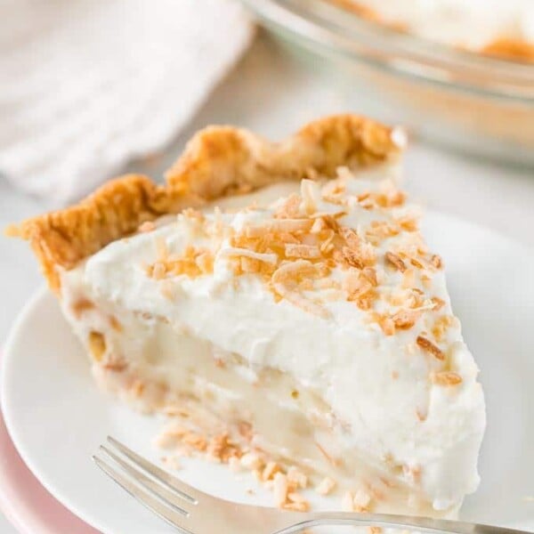 A slice of Coconut Cream Pie on a plate with a fork