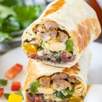 Breakfast burritos cut in half, stacked on a plate