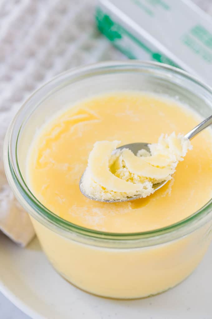 Clarified Butter in a glass jar, with a spoon.