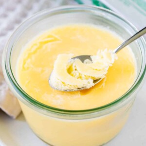 Clarified butter in a glass jar with a spoon sticking out.