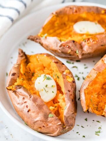 Air Fryer Sweet Potatoes on a plate topped with butter and parsley