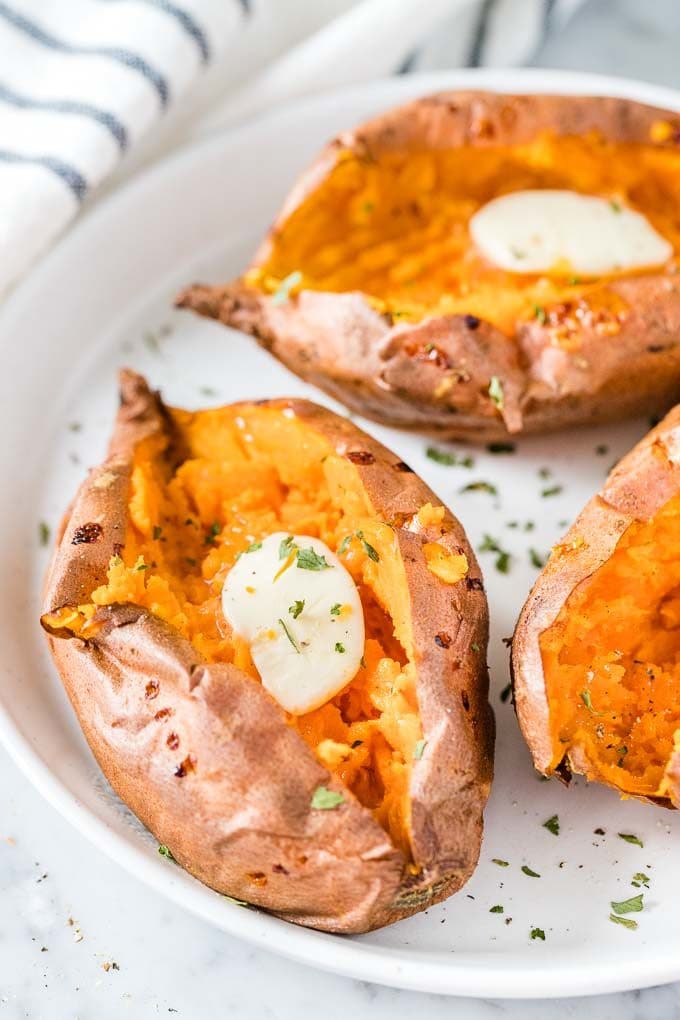 Air Fryer Sweet Potatoes on a plate topped with butter and parsley