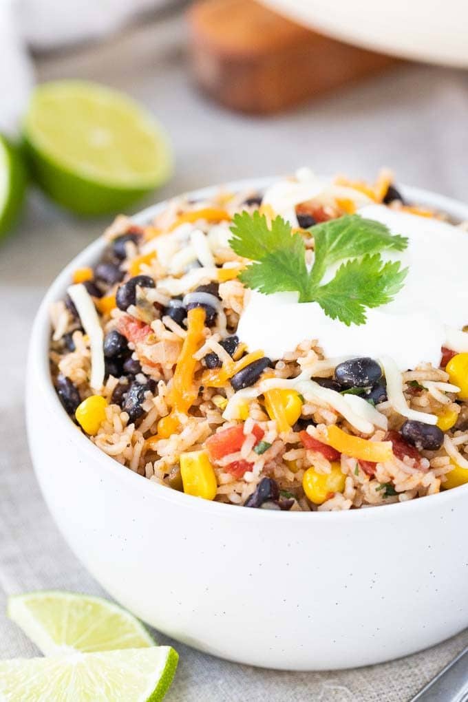 Black Beans and Rice in a bowl, topped with cheese and sour cream