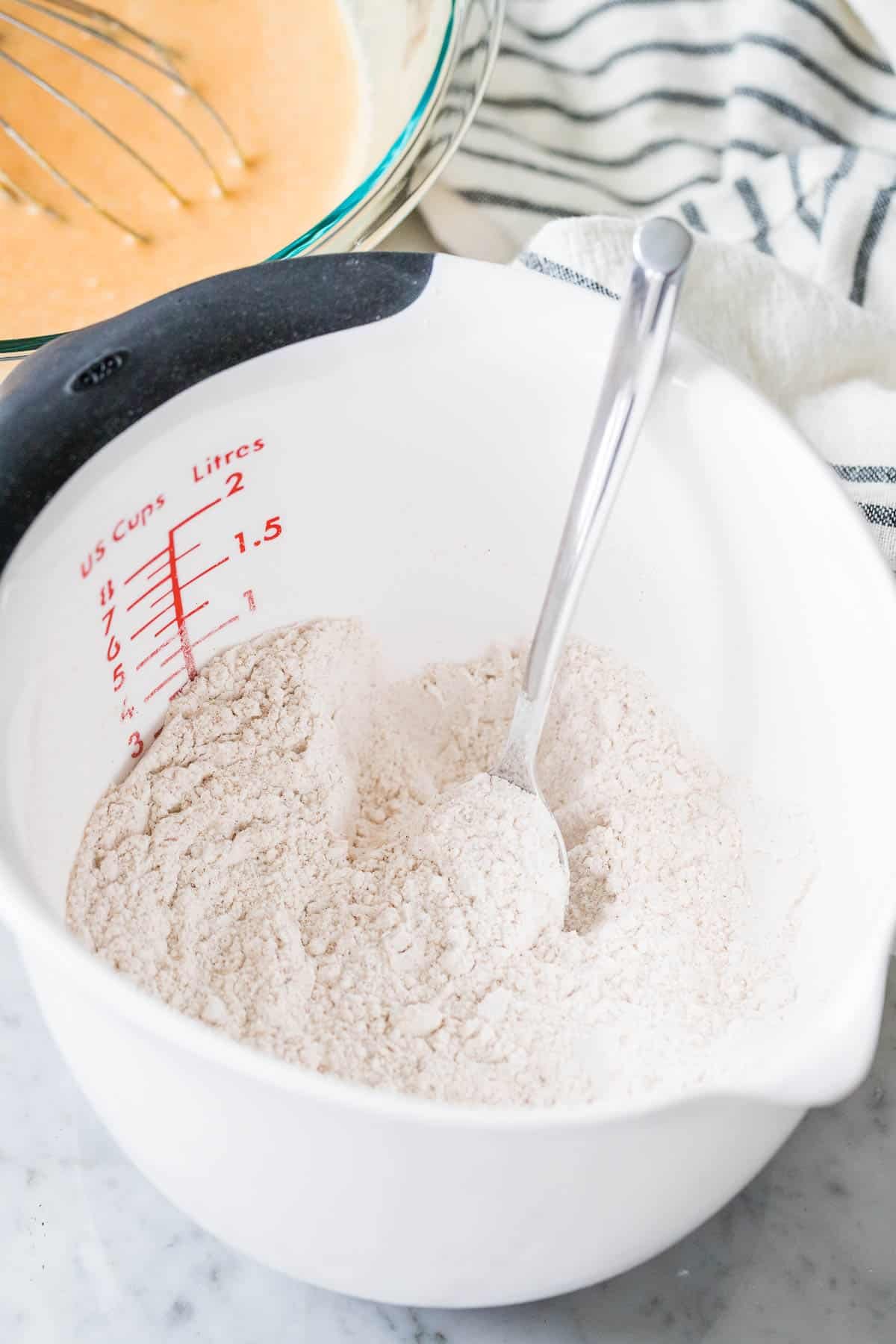 Dry ingredients in a measuring bowl with a spoon.