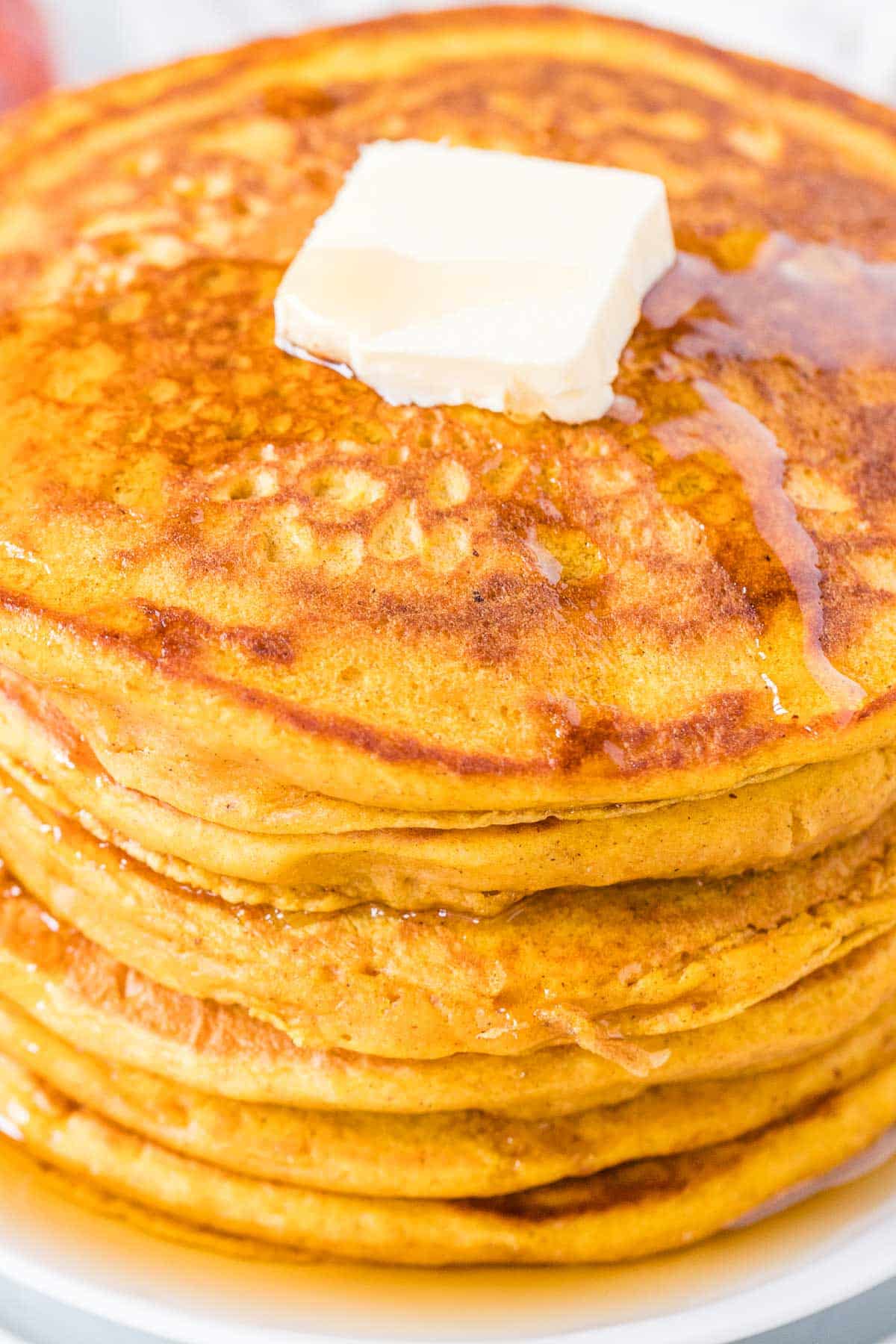 Close up of pumpkin pancakes stacked on a plate.