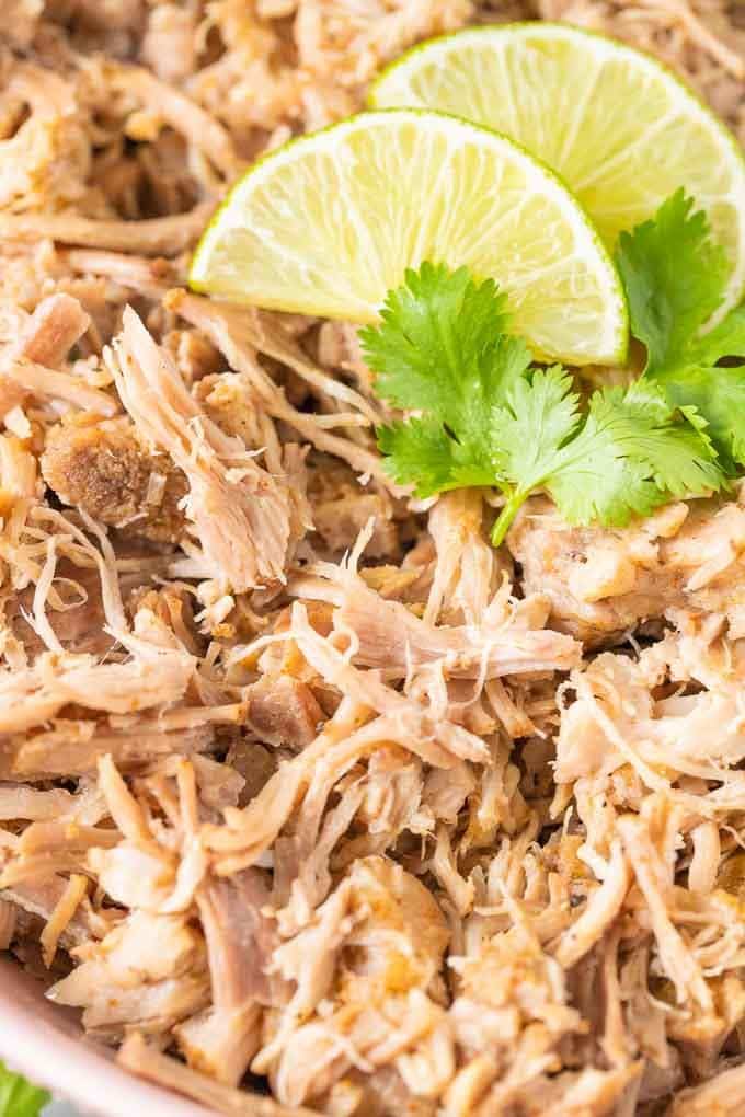 Close-up of Slow Cooker Carnitas garnished with a slice of lime and cilantro