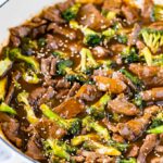 Beef and Broccoli Stir Fry in a white pan garnished with sesame seeds