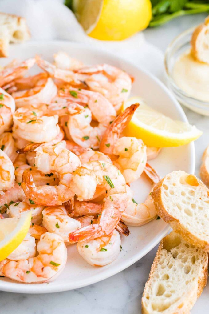 Air Fryer Shrimp on a plate with bread on the side garnished with Lemon slices