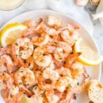 Shrimp on a plate with lemon slices and bread