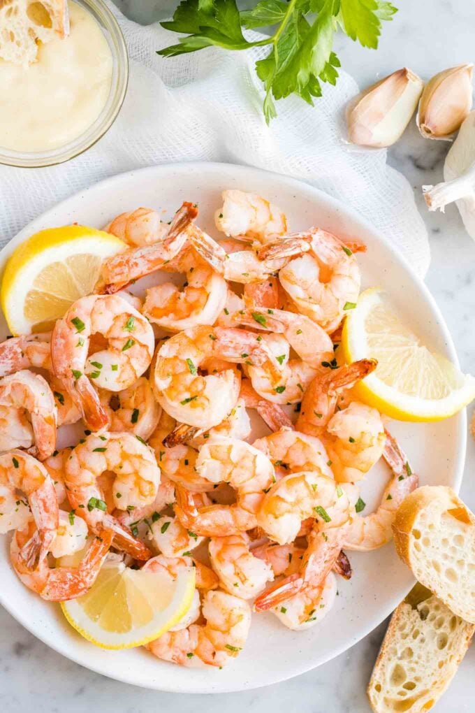 Shrimp on a plate with lemon slices and bread