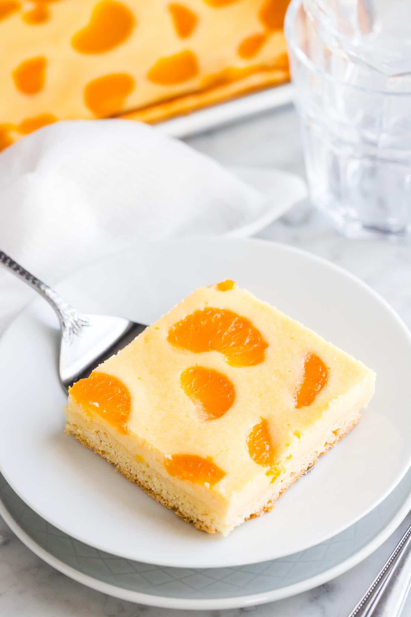 A Cheesecake Bar with mandarin oranges on a white plate