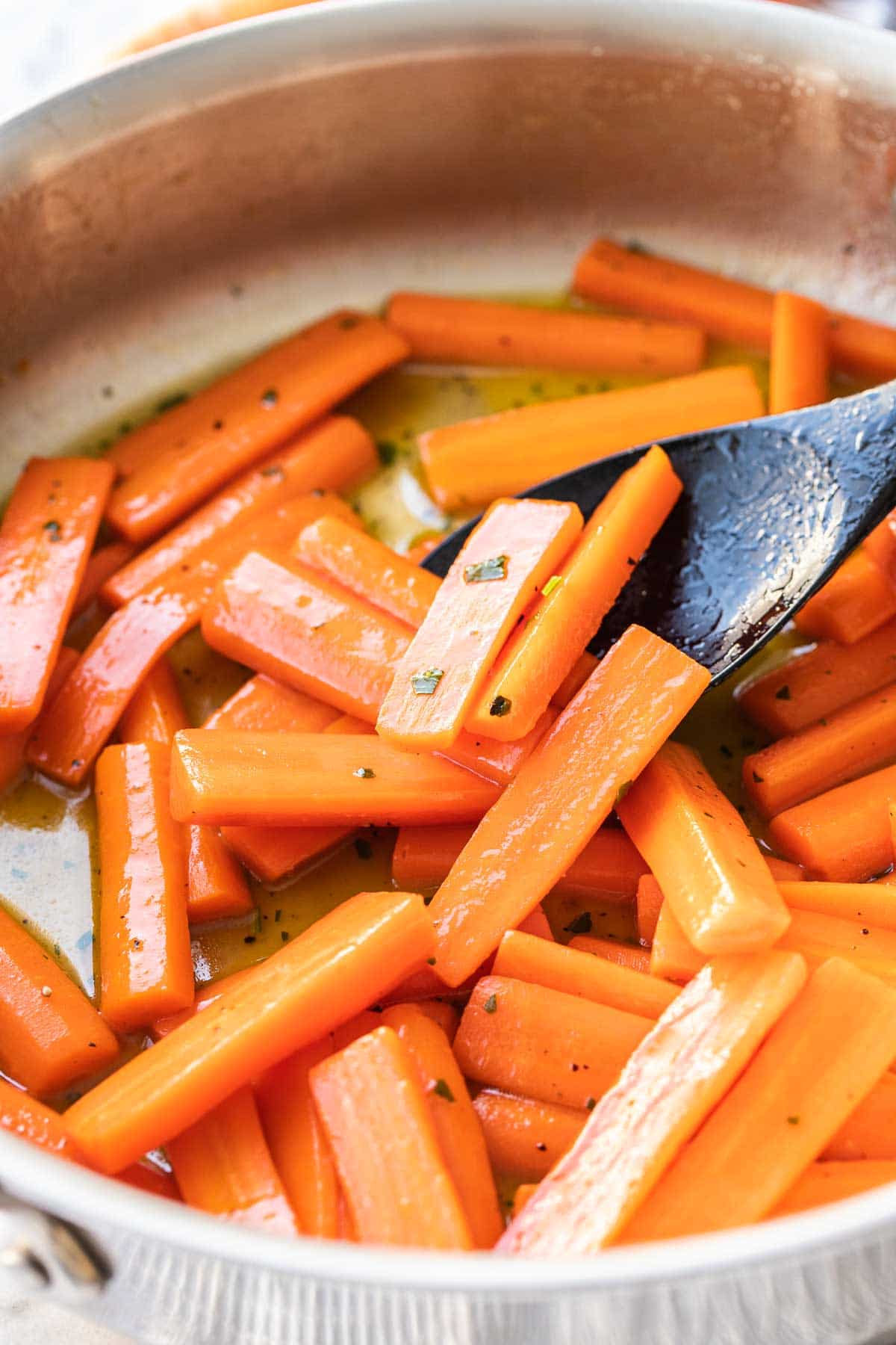 Carrots in a large skillet glazed with honey.