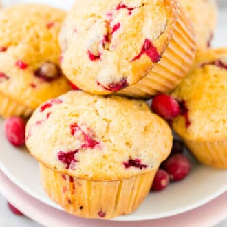 A stack of orange cranberry muffins on a white plate